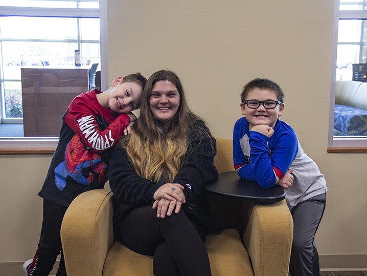 Jennifer sits center with her two sons on each side of her