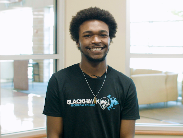 Tyrin stands in the Student Success Center wearing a black BTC t-shirt