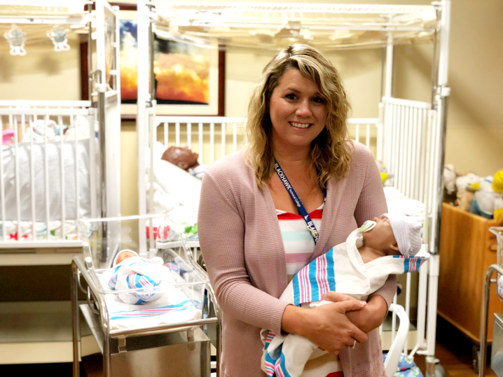 Kristy Crocker holds a baby from the SIM nursery