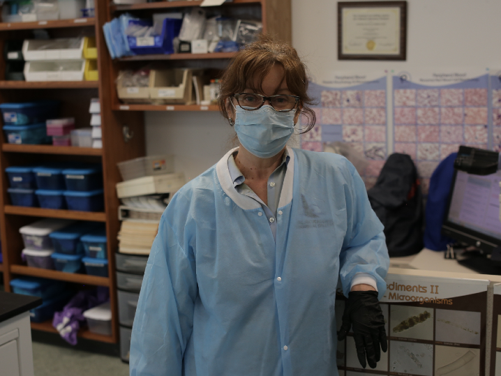 Kathi, in light blue scrubs and facemask, pictured in the lab 