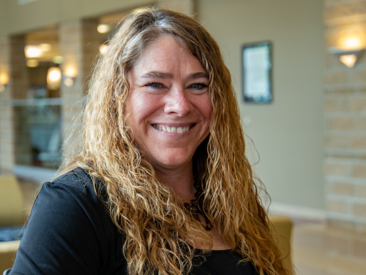 BTC Administrative Assistant Lisa smiling in front lobby of Central Campus