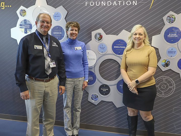 Greg Phillips (BTC), Lisa Hurda (BTC Foundation), and Kim Lantta (Blackhawk Bank) pictured in front of AMTC Donor Wall