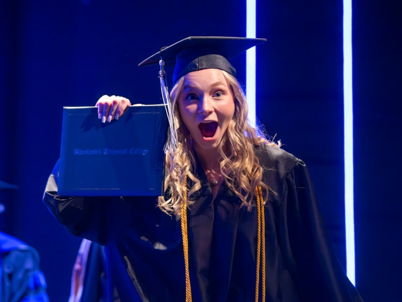 Graduate with diploma looking at camera with an expression of surprise