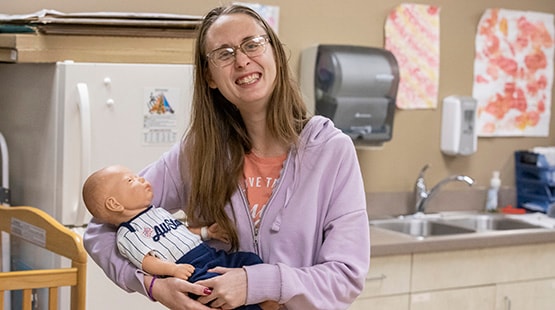 Student holding doll