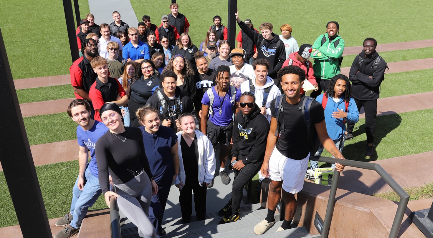 Dozens of students on the steps of the courtyard looking at the camera.