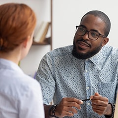 Two people in conversation with one's back turned