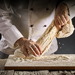 Baker or chef kneading dough