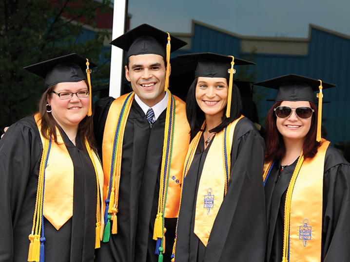 Four Graduates Smiling